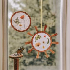 the sun and flower decorations are hanging on the window sill