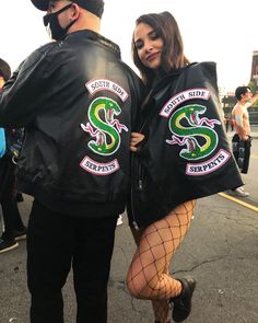 a man and woman dressed up in black leather jackets, fishnet tights and fish net stockings