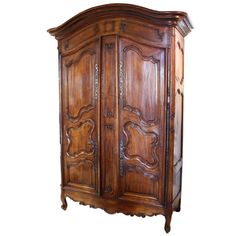 an old wooden armoire with carvings on the top and bottom panel, sitting against a white background