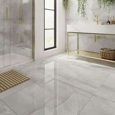 a bathroom with white walls and flooring has plants on the wall, along with a glass shower door