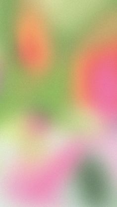 an abstract blurry background with pink, green and orange circles on the bottom right corner