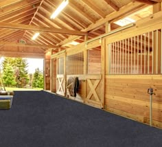 the inside of a horse barn with an open door