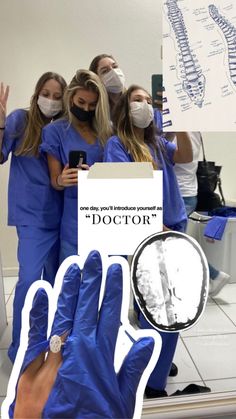 two women in blue scrubs and gloves are holding up a sign that says doctor