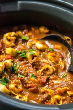 a slow cooker filled with pasta and meat