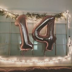 a large balloon shaped like the letter u is hanging from a string of lights in front of a window