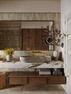 a bathroom with marble counter tops and wooden cabinets, along with two vases filled with flowers