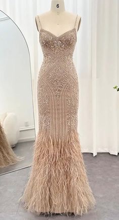 The champagne gown showcases a V-neckline and is adorned with bead and embellishments, adding a touch of shimmer. The ostrich feathers enhance its elegance, creating a graceful and ethereal silhouette. Production time is between approx 6-8 weeks. * Sizing - All items are made according to measurement ranges, they are NOT typical letter or numeric sizing. It is imperative to compare your exact measurements with the size chart provided either in the listing photos or item descriptions and to also add your measurements under Personalization. If you have any questions on sizing, please feel free to message me. Do not order your normal size without taking and comparing measurements. * EXCHANGES ONLY. Returns will not be accepted. I have explained the importance of adding your exact measurements Pearl Fringe Dress, Great Gatsby Gown, Gatsby Gown, Wedding Dress With Feathers, Champagne Gown, Feather Gown, Dresses Fancy, Crystal Dress, Cute Dress Outfits