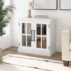 a white cabinet with glass doors in a living room