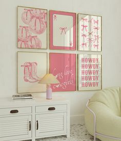 pink and white art hangs on the wall next to a small table with a lamp