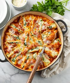 a pizza sitting in a pan on top of a table next to bowls and utensils