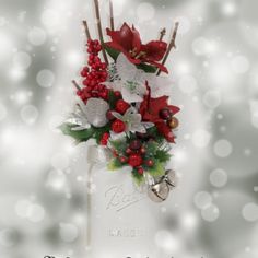 a christmas arrangement in a mason jar with holly, poinsettis and berries