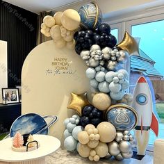 a room decorated with balloons and decorations for a space themed birthday party or baby's first birthday