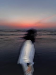 a blurry photo of a person walking on the beach