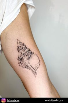 a black and white photo of a shell tattoo on the left arm, which is also in color