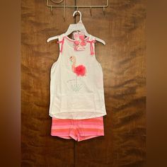 Cute Pink Striped Flamingo Short Set From Tommy Bahama In Girls Size S (5/6). Top Measurements: 24" Chest And Waist | 16-19" Length. Shorts: 22-26" Waist | 8" Length | 2" Inseam. Girls Outfit Includes Shorts, A Tank Top, And Bow Clips. Tank Top Is Solid White With Pink Details. Two Bows On The Shoulders. Cute Flamingo On The Front With Tassel Details. High-Low Style Hem. Sleeveless With Scoop Neck. Matching Shorts Are Pink And Red Striped. Elastic Waist For The Perfect Fit. Two Faux Pockets In T Tommy Hilfiger White Casual Shorts, Pink Short Tops For Beach Season, Short Pink Tops For Beach Season, Pink Tops For Playwear During Beach Season, Pink Top For Playwear During Beach Season, Tommy Hilfiger Pink Summer Tops, Flamingo Shorts, Cute Flamingo, Pink Details