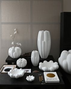 there are many white vases and other items on the table in front of them