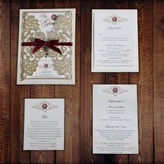 the wedding stationery is laid out on wooden paneled walls with red ribbon tied around it