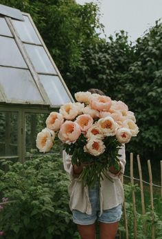 a woman holding a bunch of flowers in her hands