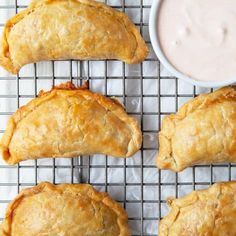 four pastries on a cooling rack with dipping sauce