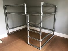 a metal bed frame sitting on top of a hard wood floor next to a wall