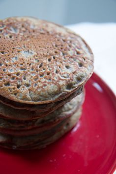 a stack of pancakes sitting on top of a red plate