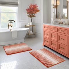 a bathroom with two rugs and a bathtub in the middle of the room