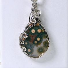 Presenting a hand-cut large teardrop pendant that exudes elegance and uniqueness. The stone is expertly polished, resulting in a smooth and lustrous surface.  This particular color and pattern are rare and not frequently seen, as they come from old stock material. The pendant features a timeless wire wrap design crafted from sterling silver. It is gracefully suspended from a beaded necklace adorned with freeform jasper nuggets and round natural Rhyolite jasper beads. The necklace is finished wit Bunny Jewelry, Wire Wrap Jewelry, Best Friend Necklaces, Art Deco Pendant, Wrap Jewelry, Teardrop Pendant, Jasper Pendant, Jasper Beads, Ocean Jasper