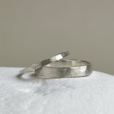 two silver rings sitting on top of each other