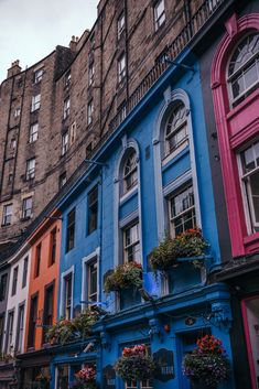 an old building with many windows and flowers on the balconies in front of it