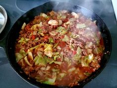 a large skillet filled with lots of food on top of a stove burner