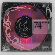 a cd that is sitting on top of a plastic case with pink and purple designs