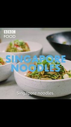 two white bowls filled with food on top of a table