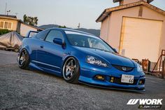 a blue car parked in front of a house