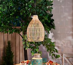 a bird cage hanging from the side of a table with plates and cups on it