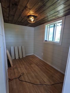 an empty room with wooden floors and white walls