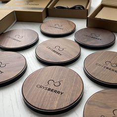 six wooden coasters with the name crissberry on them sitting next to boxes