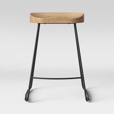 the backless stool is made from black metal and wood, with a wooden seat