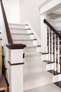 the stairs in this house are decorated with white and brown herringbones