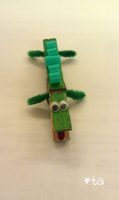 a toy car made out of green paper with eyes and ears sitting on top of a table