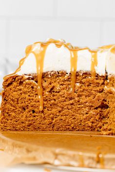 a close up of a slice of cake with frosting on top and caramel drizzle