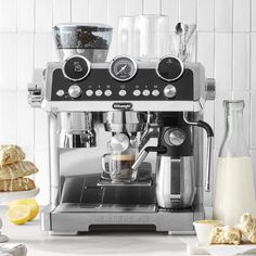 an espresso machine sitting on top of a counter next to sliced lemons