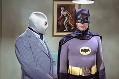 two men dressed up as batman and the man in suit is talking to each other