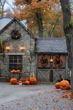 some pumpkins are sitting on the ground in front of a stone house with lights