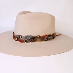 Natural feather hat band. Adjustable with a leather tie. Natural colored feathers Adjustable hatband Approx. 1 inch wide *This product is for 1 single hat band. Hat not included. Adjustable White Hat Band For Fall, Adjustable Cream Hat Bands For Fall, Leather Feather Hat Band, Bohemian Hat Bands With Feathers For Western-themed Events, Feathered Hat Bands For Western-themed Events, Brimmed Hat Bands With Feather Trim For Western-themed Events, Cowboy Hat Feather Band, Feather Hat Band, Colored Feathers