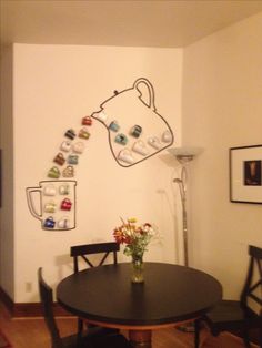 a dining room table with chairs and a vase filled with flowers on top of it