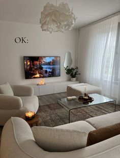 a living room filled with furniture and a flat screen tv mounted to the side of a wall