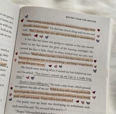 an open book with some writing on the page and two hearts in the pages next to it