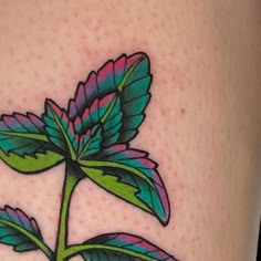 a close up of a flower on the side of a woman's leg with tattoos