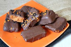 chocolate covered donuts with sprinkles on an orange plate