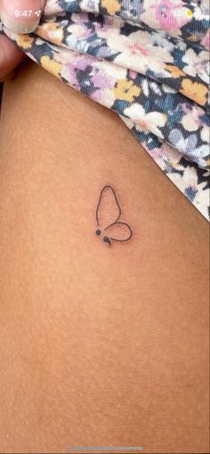 a woman's stomach with a small heart tattoo on the lower side of her belly